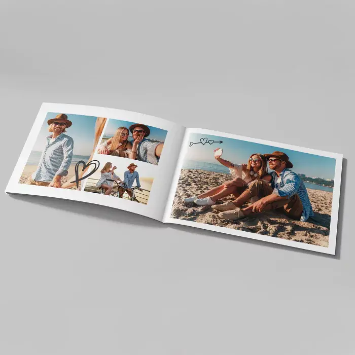 Open personalised photo book featuring a couple's beach vacation photos. The photobook has a clean, modern design with heart embellishments, making it a perfect gift idea for Valentine's Day, anniversaries, or special occasions. Ideal for creating lasting memories.