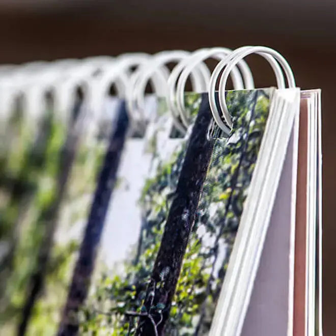 Close-up image of a spiral-bound photo book with high-quality printed pages. The book features a sturdy white wire binding and glossy pages showcasing vibrant, detailed photographs. Ideal for personalised gifts, photo albums, and special occasions such as Christmas or Valentine's Day.