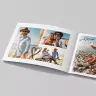Open photo book displaying a collage of beach photos featuring a couple enjoying a sunny day. The book has a clean, modern design with white pages and simple black doodles, including hearts and arrows. Ideal for personalised gifts, photo albums, and special occasions like Valentine's Day or Christmas.